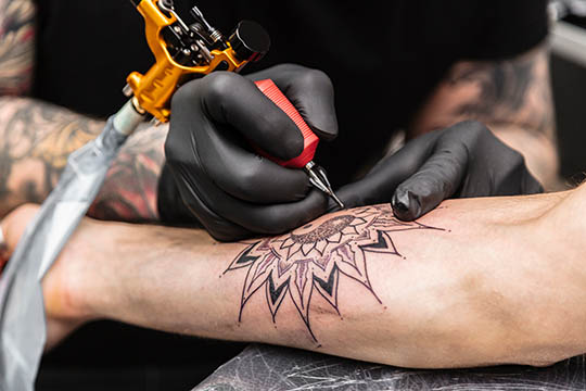 Tatuażysta wykonujący tatuaż
